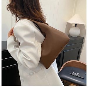 Sac hobo en cuir marron porté avec un blazer blanc pour un look professionnel chic