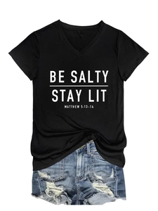 Détail macro de l'imprimé BE SALTY STAY LIT sur t-shirt col V avec short en jean usé
