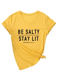 Détail d'un t-shirt jaune moutarde à col en V avec imprimé et nœud décoratif devant