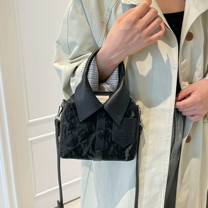 Minimalist black leather handbag featuring a creative shirt collar and button design