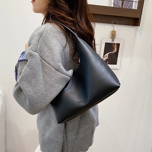 Sac à bandoulière demi-lune en cuir noir minimaliste avec une poignée intégrée élégante