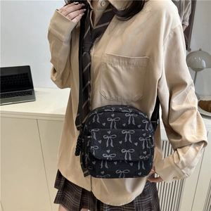 Sac bandoulière en velours noir imprimé nœuds et cœurs dans un style rétro