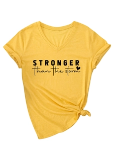 Detail of V-neck yellow T-shirt with 'Stronger than the storm' slogan and front knot design