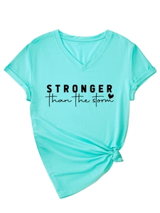 Close-up of stronger than the storm text and knotted hem on mint green V-neck T-shirt