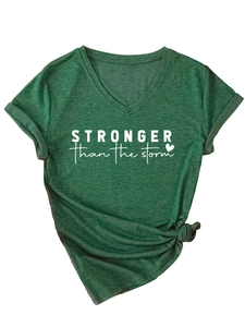Detail of dark green V-neck T-shirt with white stronger than the storm text and knotted hem