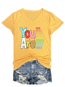 Detail of yellow V-neck T-shirt with 'You Are Kind Brave Smart' text and denim shorts