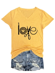 Détail du t-shirt jaune col en V love avec un short en jean bleu délavé et usé