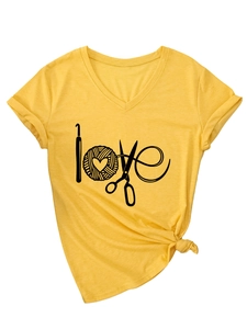 Détail du t-shirt jaune à col en V avec motif LOVE en outils de tricot et ourlet noué