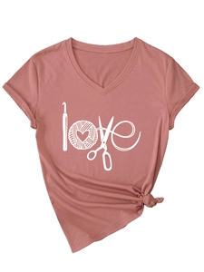 Détail du t-shirt rose poudré à col en V avec imprimé love et ourlet noué