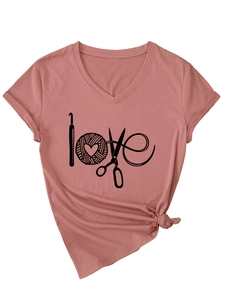 Détail d'un t-shirt à col en V rose poudré avec motif love créatif et éléments de tricot