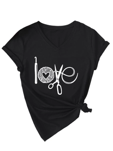 Détail du t-shirt noir col en V avec motif love tricoté et ourlet noué sur le côté