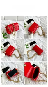Macro detail of red quilted shoulder bag with gold chain strap and interior storage capacity
