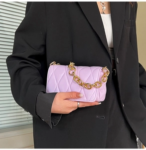 Detail of light purple quilted handbag featuring a chunky gold metal chain handle