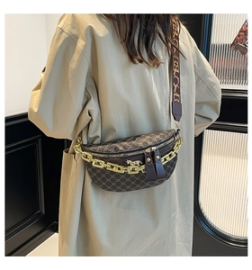 Close-up of saddle bag featuring gold chain, horse pendant, and wide patterned strap