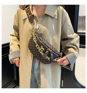Detailed view of vintage patterned saddle bag with gold chain and wide shoulder strap