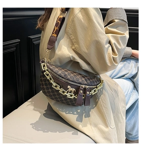 Detail of vintage crossbody bag with gold chain strap and horse pendant decoration