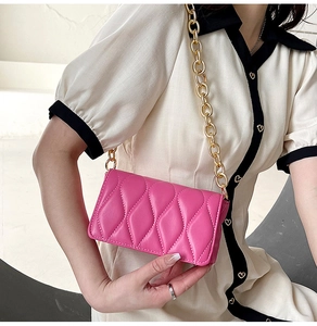 Detail of rose pink quilted crossbody bag featuring wave texture and gold chain strap