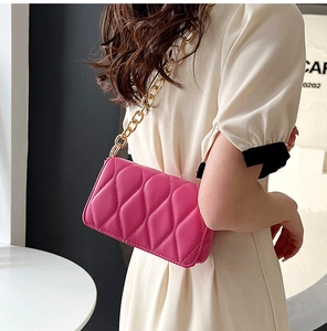 Detail of rose pink crossbody bag with wave quilting and chunky gold chain strap