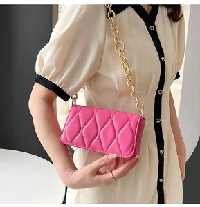 Chic pink quilted crossbody bag featuring a chunky gold chain strap and wave texture