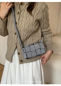 Detail view of monochrome monogram shoulder bag with black leather trim and woven pattern