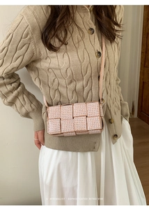 Detail of woven square crossbody bag featuring intricate cream and white texture patterns