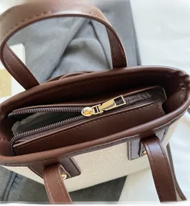 Gros plan sur la fermeture éclair dorée du sac cabas bicolore avec surpiqûres précises
