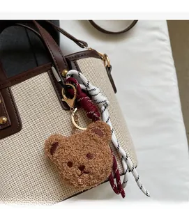 Détail d'un porte-clés d'ours en peluche marron attaché à une lanière de sac à main