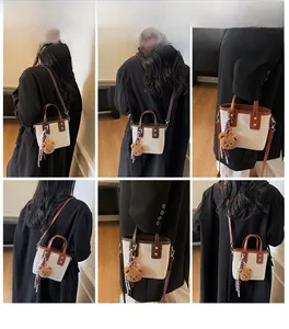 Vues détaillées d'un mini sac seau en toile avec garniture en cuir brun et pendentif ours