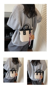 Détail du sac seau en toile avec bordure en cuir noir et breloque ours en peluche