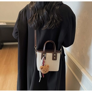 Sac fourre-tout en toile avec bordure en cuir marron et breloque ours sur manteau noir