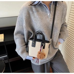 Sac seau chic en toile beige avec bordure en cuir noir et breloque ours en peluche
