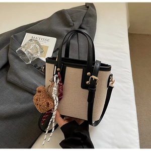 Détail du sac seau en toile avec finitions cuir et charmant petit ours en peluche brun