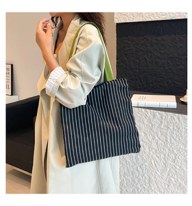 Vue détaillée d'un sac fourre-tout en toile à rayures noires et blanches et sangle verte