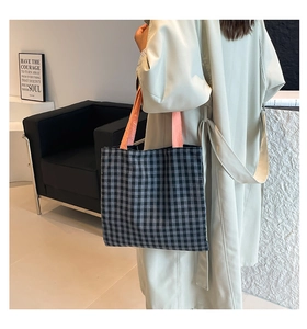 Chic checkered tote bag with pink handles shown over a beige trench coat