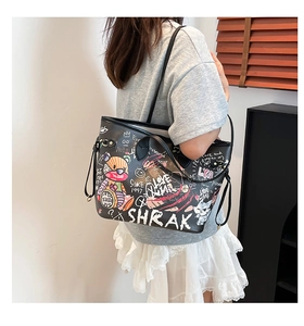 Detail view of black PU leather tote bag featuring colorful street graffiti and cartoon bear