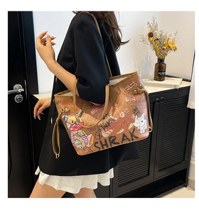 Brown tote bag with colorful graffiti bear prints worn by a model in a black suit