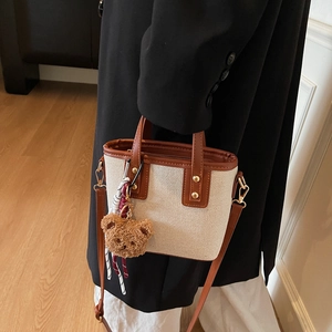 Mini sac seau en toile crème avec finitions en cuir marron et pendentif ours peluche