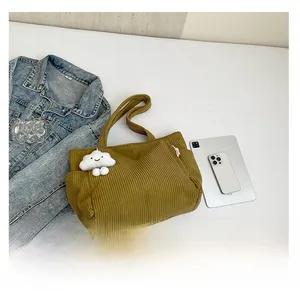 Detail view of mustard corduroy tote bag with side zipper pocket and cloud charm