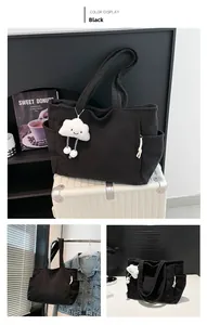 Detail view of black corduroy tote bag with side pocket and cloud plush charm