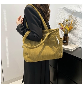 Detail of mustard yellow corduroy tote bag with side pocket and wide shoulder strap