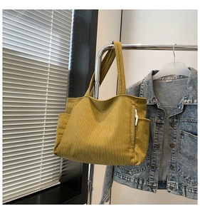 Detail view of ginger yellow corduroy tote bag with side pockets and cord decoration