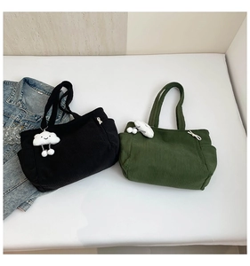 Detail of corduroy tote bags in black and dark green with cute cloud plush charms