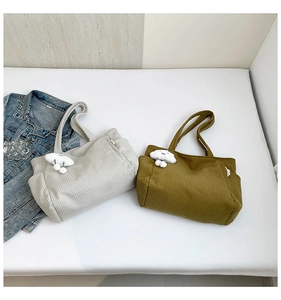Detail of corduroy tote bags in grey and olive green featuring cute cloud pendants