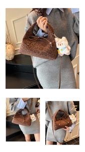 Detail of leopard print handbag with plush bear charm and crossbody leather strap