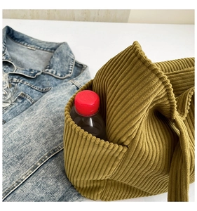 Detail view of mustard yellow corduroy tote bag showing a side pocket with a water bottle
