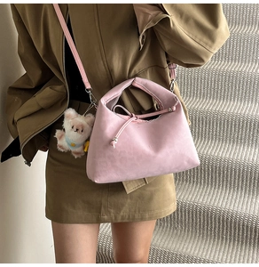 Detailed view of pink pillow bag with drawstring design and cute plush bear charm