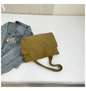 Flat lay of olive green corduroy tote bag showing textured vertical ribbed fabric detail