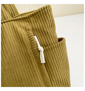 Close-up of mustard green corduroy tote bag featuring a white cotton rope knot detail