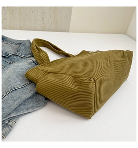 Detailed close-up of olive green corduroy tote bag texture with large square capacity