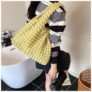 Detail of light yellow bubble texture tote bag with stylish bow and spacious interior